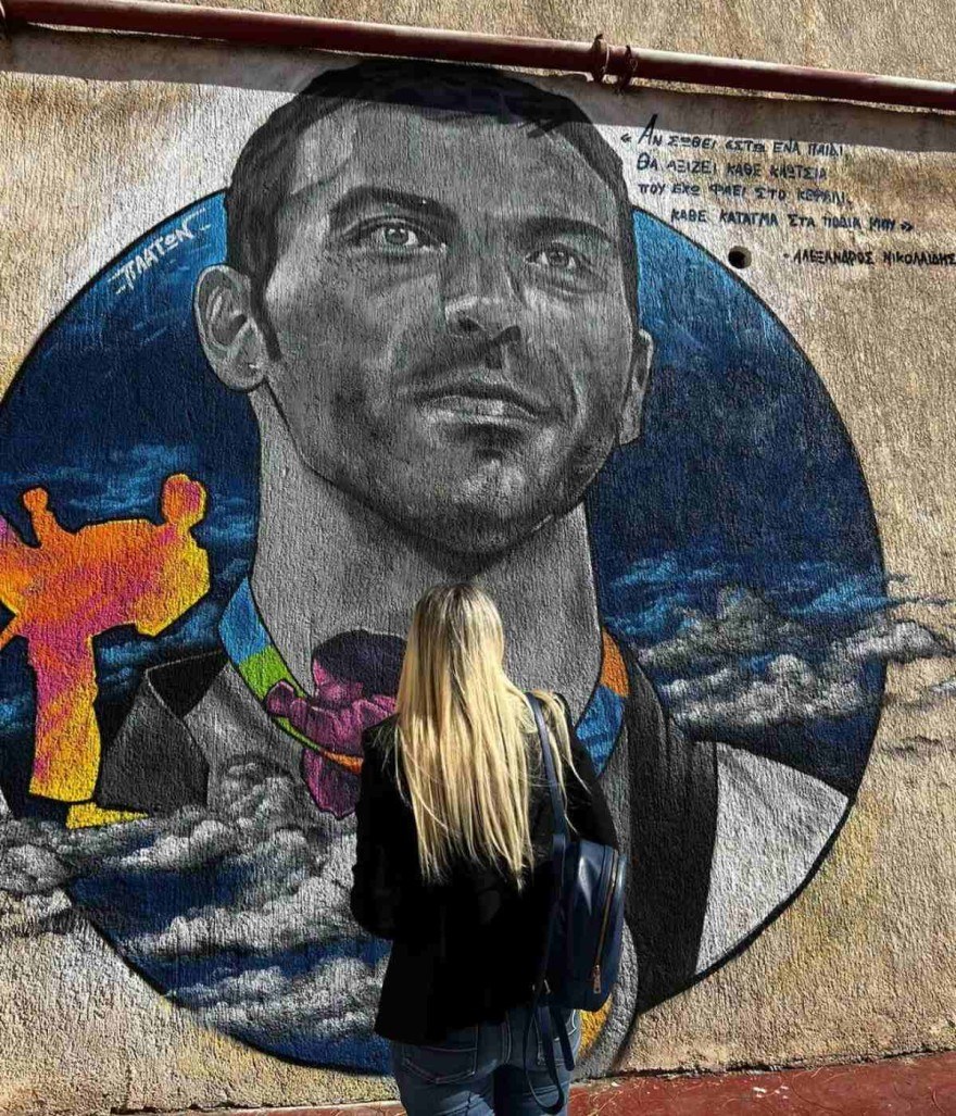 Η φωτογραφία της συζύγου του Αλέξανδρου Νικολαϊδη μπροστά από το γκράφιτι στη μνήμη του