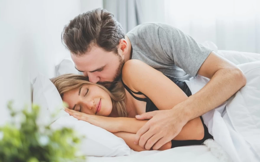 ζευγάρι αγκαλιάζεται πάνω στο κρεβάτι