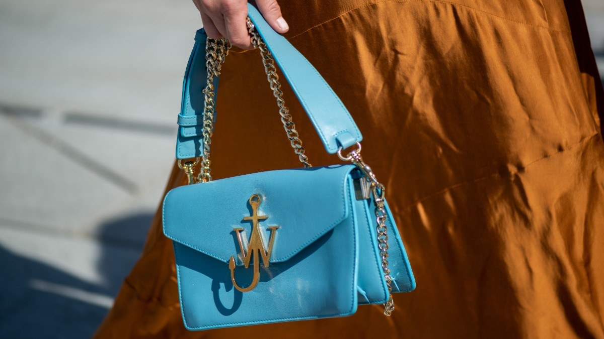 color trends στο street style με μοντέλο να κρατάει γαλάζια τσάντα