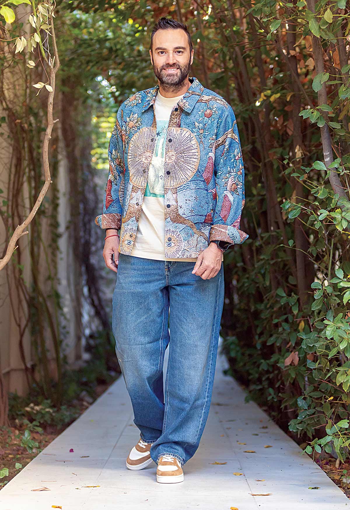 Ο Κώστας Φραγκολιάς με overshirt και t-shirt με στάμπα, Scotch & Soda, τζιν παντελόνι, Diesel και sneakers