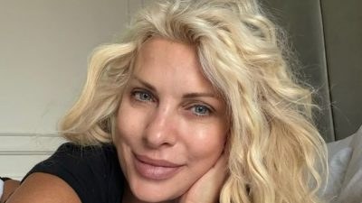 Η Ελένη Μενεγάκη με σγουρά μαλλιά ξαπλωμένη στο κρεβάτι