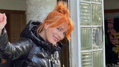 Η Σμαράγδα Καρύδη με μαύρο μπουφάν χαμογελάει στον φακό