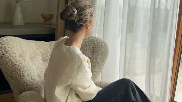 Χειμανιάτικο look από γυναίκα μπροστά σε παράθυρο