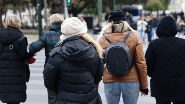 Άνθρωποι να περπατάνε φορώντας τα μπουφάν τους