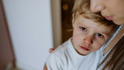 Ένα στεναχωρημένο παιδί στην αγκαλιά της μαμάς του