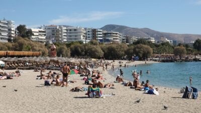 παραλία γεμάτη κόσμο που κάνει μπάνιο