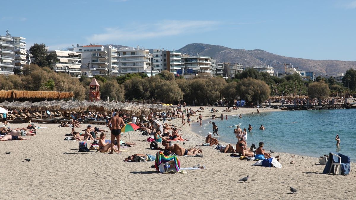 παραλία γεμάτη κόσμο που κάνει μπάνιο
