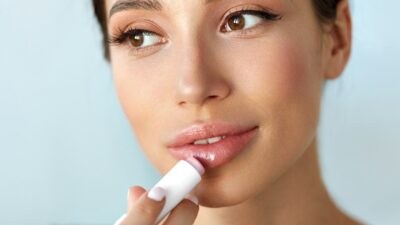 ένα κορίτσι βάζει lip gloss