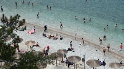 Κόσμος κάνει μπάνιο στην παραλία
