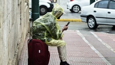 ένας άντρας στο δρόμο με αδιάβροχο