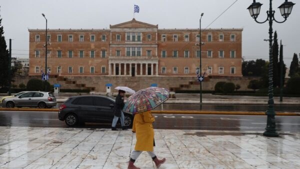 μια γυναίκα με ομπρέλα στην βροχή Αθήνα